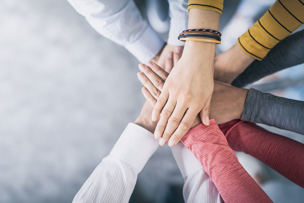 Close Up Top View Of Young Business People Putting Their Hands T