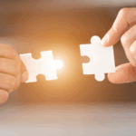 Dve roki držita dva osvetljena koščka sestavljanke