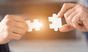 Dve roki držita dva osvetljena koščka sestavljanke